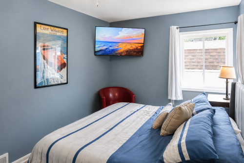 Master bedroom with a king-sized bed, private bathroom, and a flat-screen TV