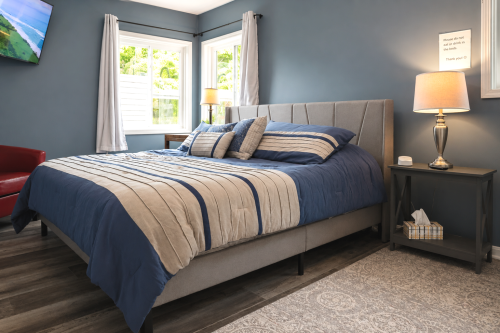 Master bedroom with a king-sized bed, private bathroom, and a flat-screen TV