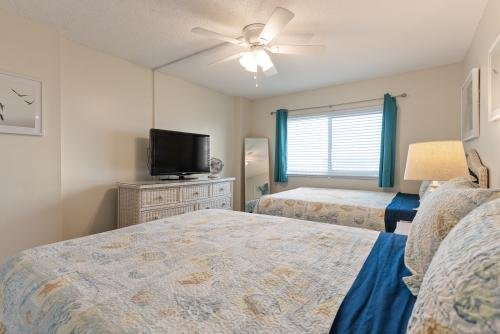 Second bedroom with 2 queen-sized beds, a flat-screen TV, closet space and windows overlooking the intercoastal 