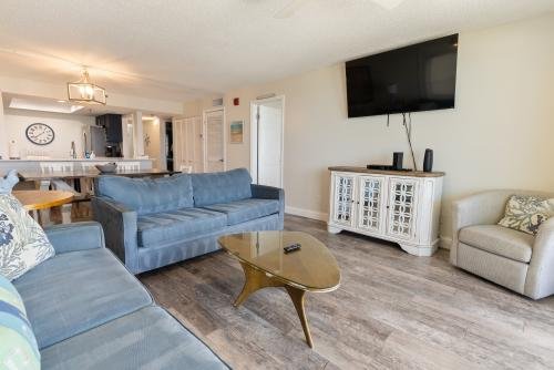 Living room with flat-screen TV, overlooking the kitchen and dining area
