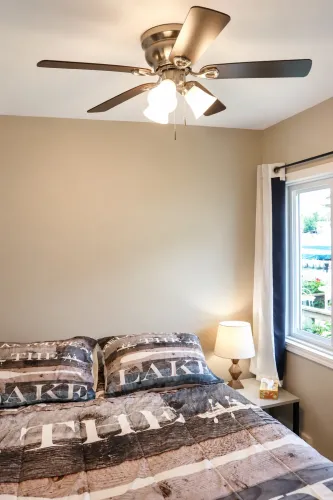 A comfortable bedroom featuring a queen-sized bed along with a range of modern amenities