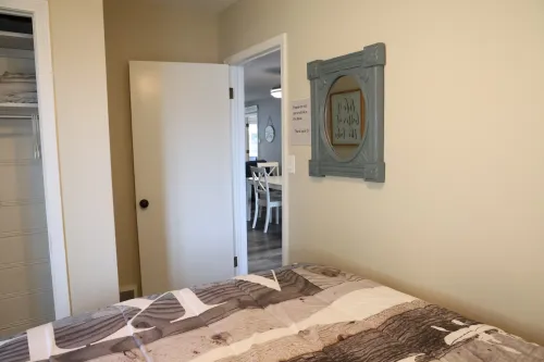 Side view of the bedroom featuring a queen-sized bed and overlooking the dining area