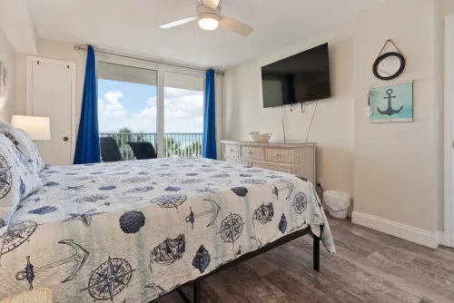 Comfortable king-size bedroom with a TV, closet, and private balcony