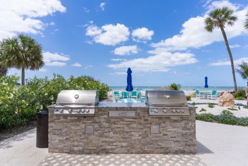 Gas grills with plenty of seating next to pool in hot tub