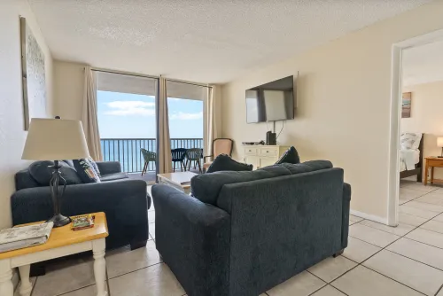 Living room overlooking the ocean comprising balcony and a flatscreen TV