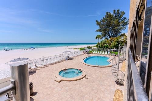 Ocean front view with spiral staircase, going down to heated pool, hot tub, and gas grills 